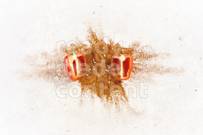 A bunch of ground paprika powder with two halfs of red bell pepper on white background