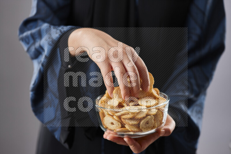 Woman in abaya holding different kinds of snacks in different positions