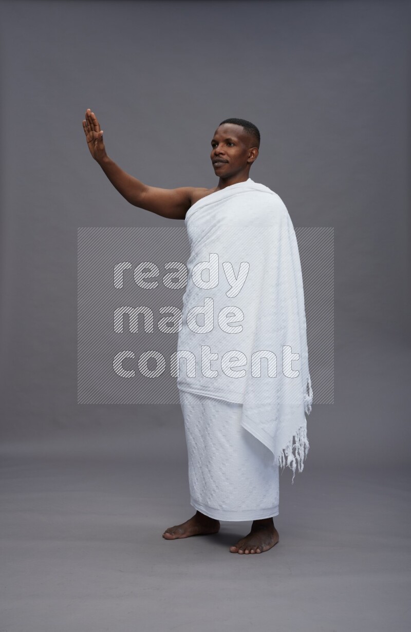A man wearing Ehram Standing Interacting with the camera on gray background