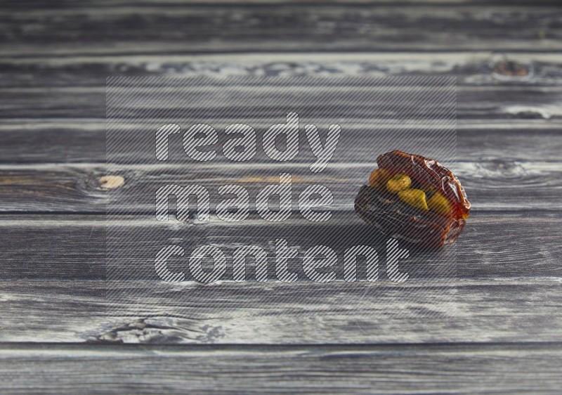 pistachio stuffed madjoul date on a wooden grey background