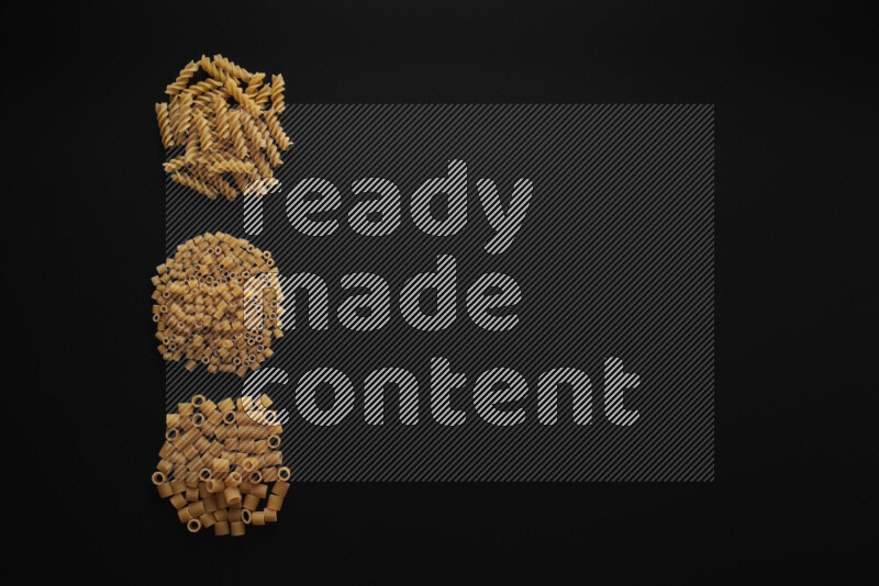 Different pasta types in 3 bunches on black background