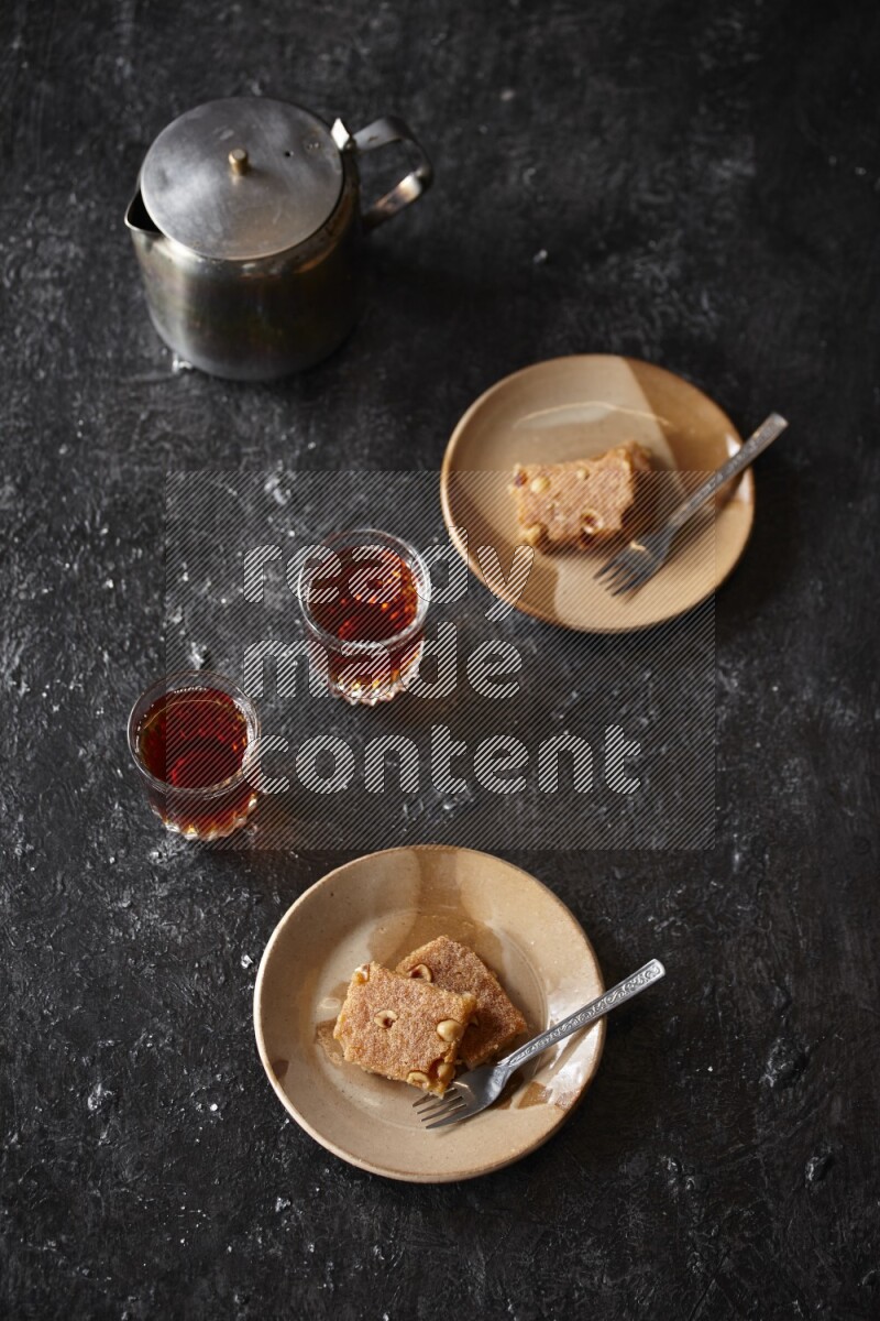 بسبوسة مع الشاي علي خلفية سوداء خشبية