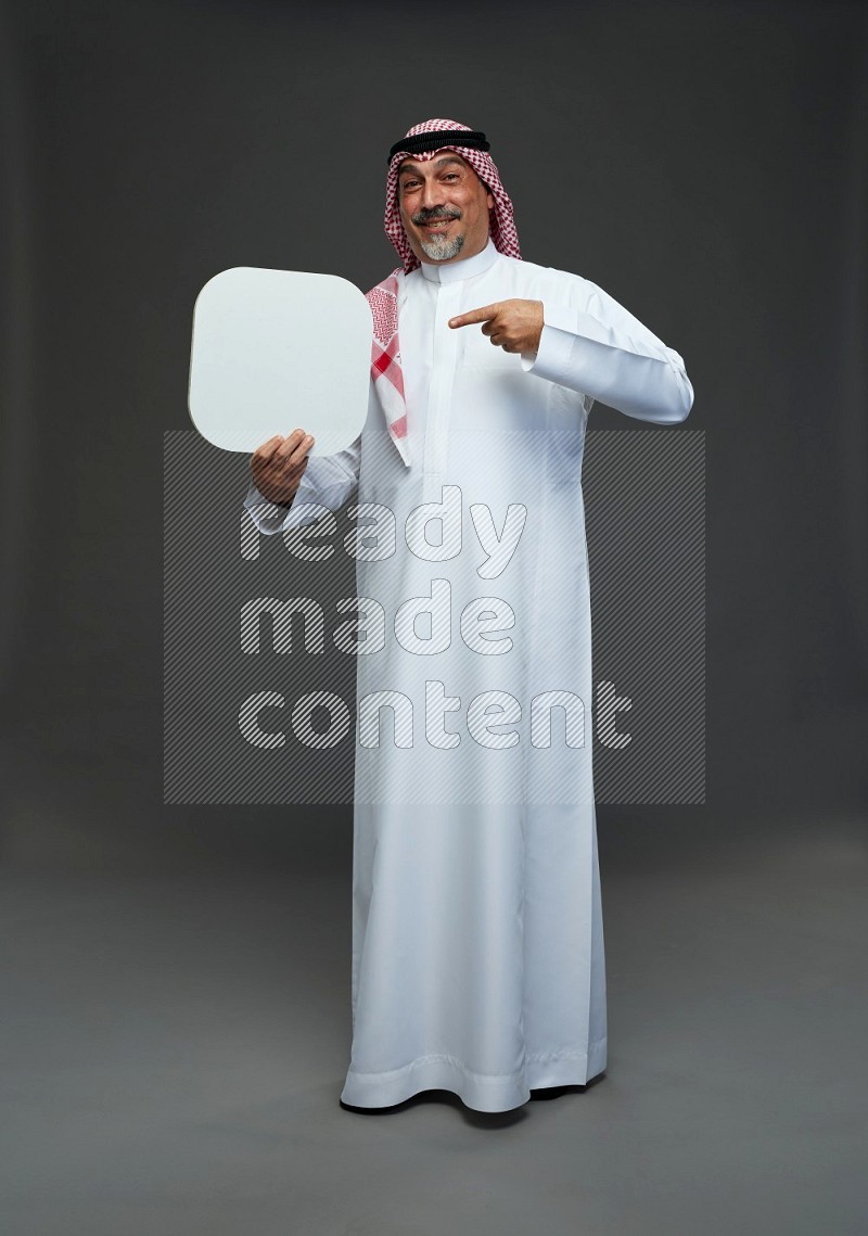 Saudi man with shomag Standing holding social media sing on gray background