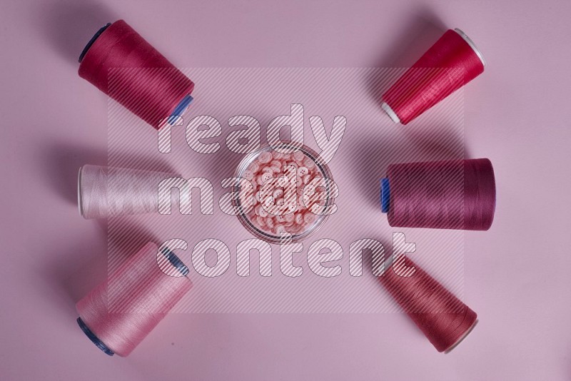 Pink sewing supplies on pink background