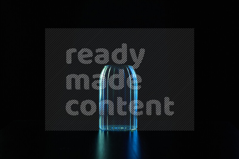 Glassware with rim light in blue and green against black background