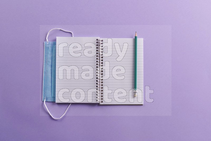 A blank open notebook with school supplies on purple background (Back to school)