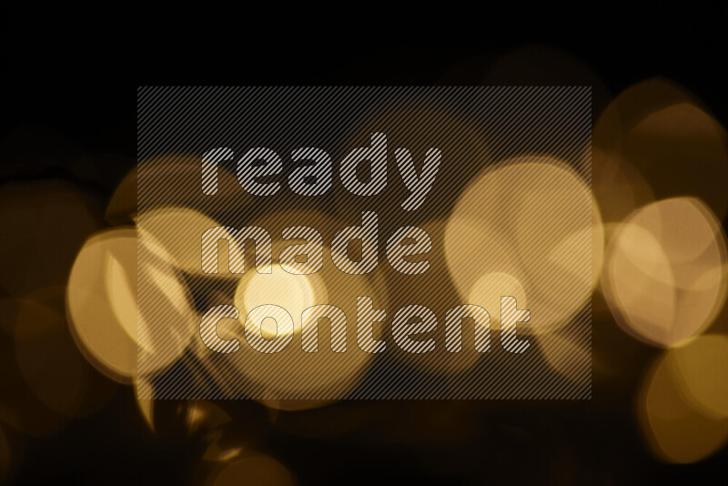 Light bulbs glowing against backdrop of golden bokeh
