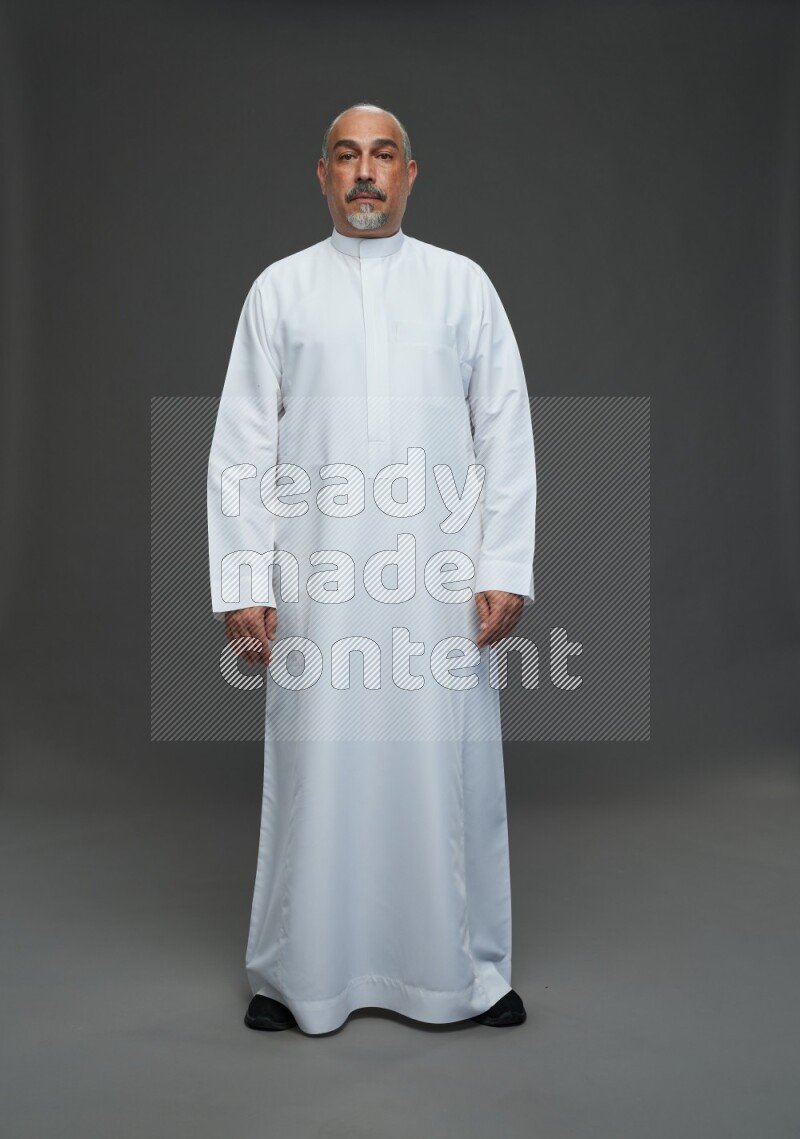 Saudi man without shomag Standing Interacting with the camera on gray background