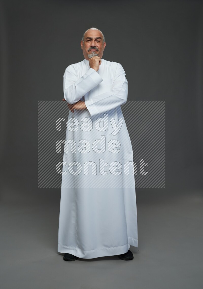 Saudi man without shomag Standing Interacting with the camera on gray background