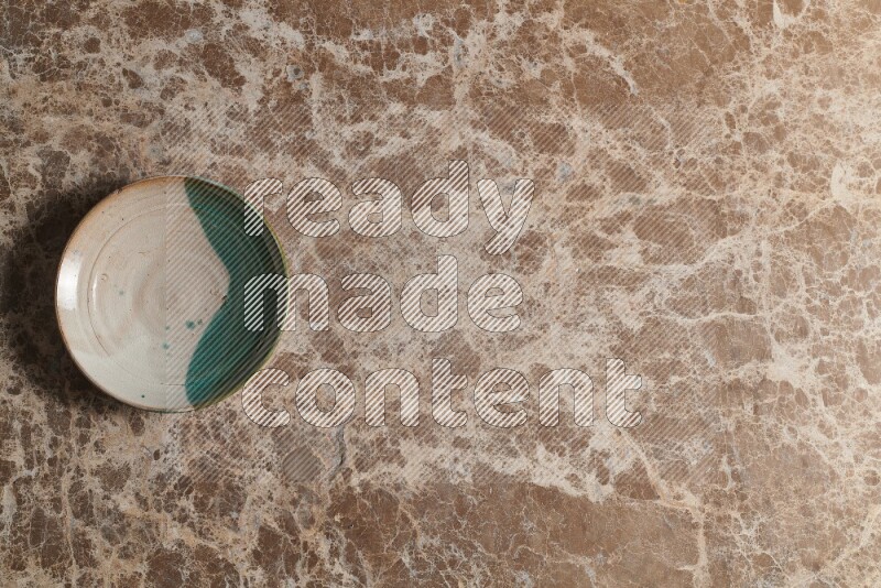 A decorative pottery plate on beige marble background