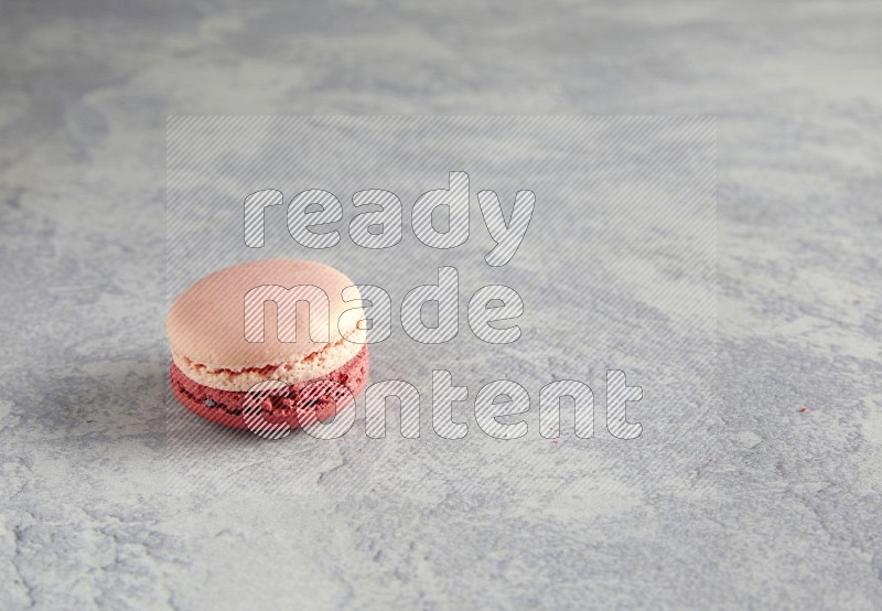45º Shot of Pink Litchi Raspberry macaron on white  marble background