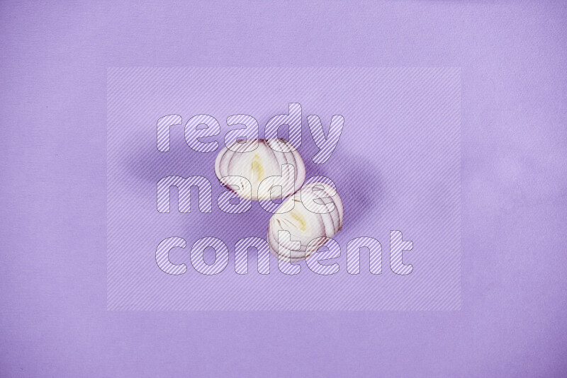 Halves red onions on a purple background