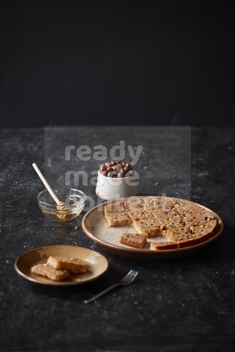 Basbousa with nuts and honey in a dark setup