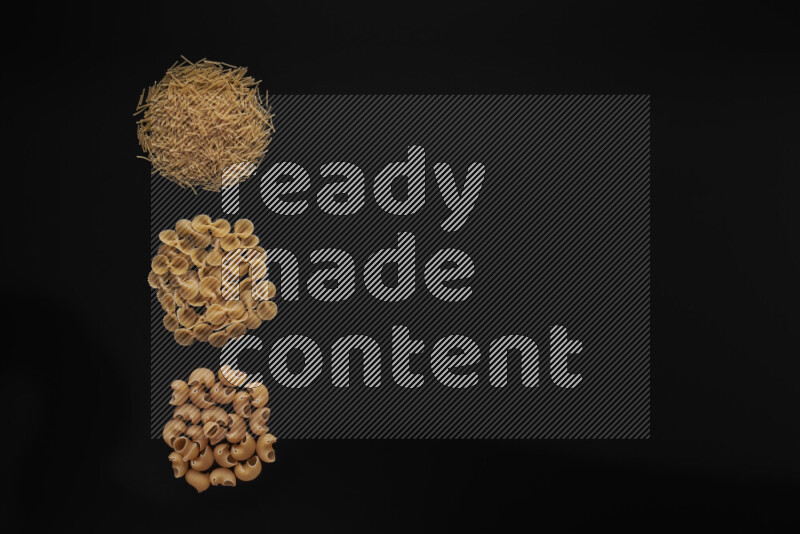 Different pasta types in 3 bunches on black background