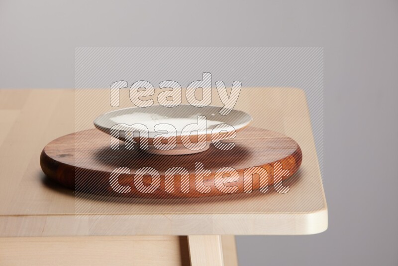 multi-colored pottery Plate placed on a dark colored wooden tray on the edge of wooden table