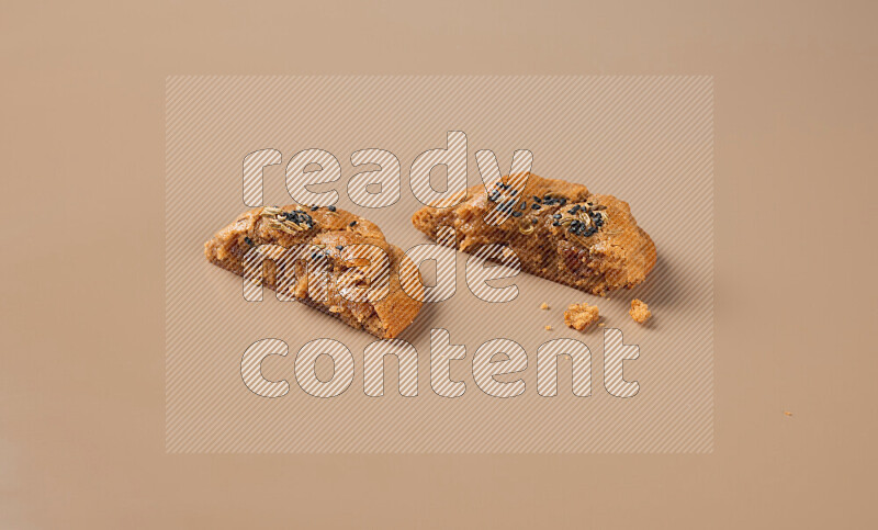 a Hasawi cookie field of date and herbs with another one cut in half on a brown background