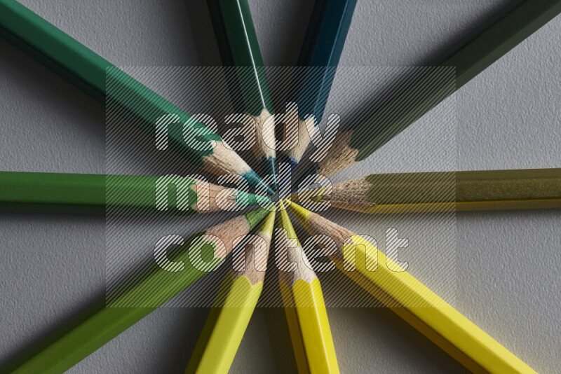 An arrangement of colored pencils in different colors on grey background