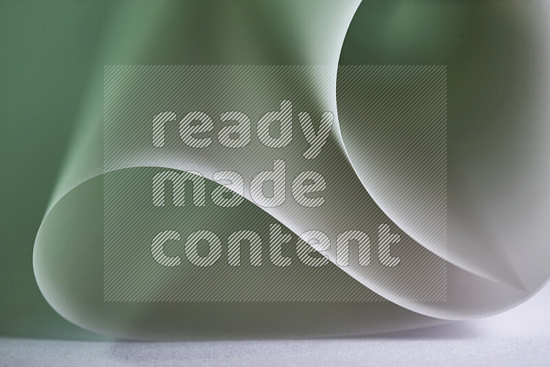 An abstract art piece displaying smooth curves in green and grey gradients created by colored light