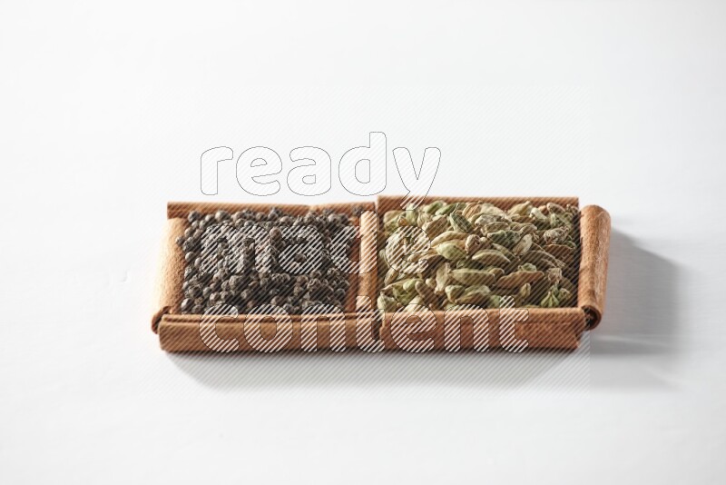 2 squares of cinnamon sticks full of cardamom and black pepper on white flooring