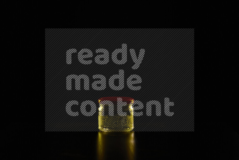 Glassware with rim light in yellow against black background