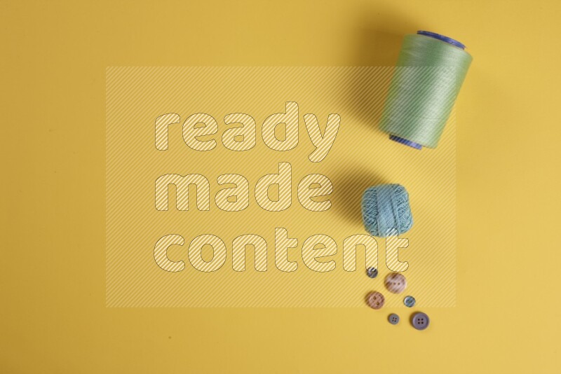 مجموعة من أدوات الخياطة والتفصيل خضراء اللون على خلفية صفراء