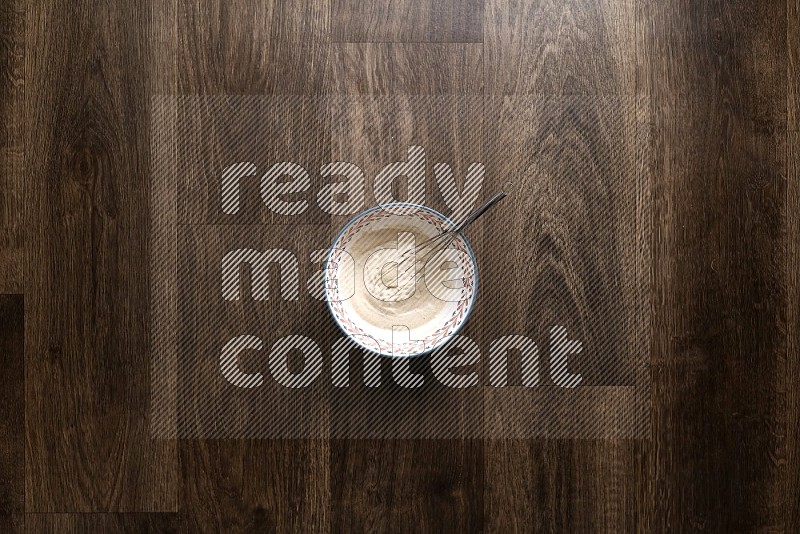 A bowl full of spices and salad dressing ingredients on wooden background