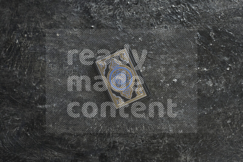 Quran with a prayer beads on textured black background