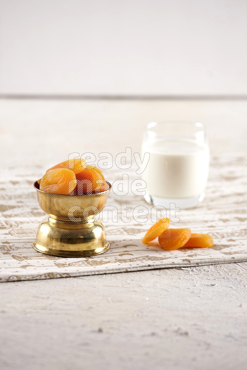Dried fruits in a metal bowl with milk in a light setup