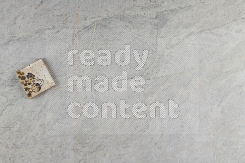 A decorative pottery coaster on grey marble background