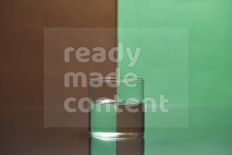 The image features a clear glassware filled with water, set against brown and green background