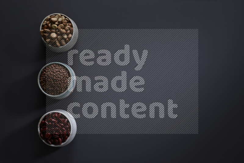 Legumes in pottery bowls on grey background