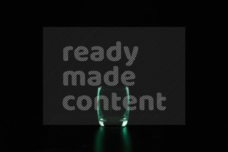 Glassware with rim light in green against black background