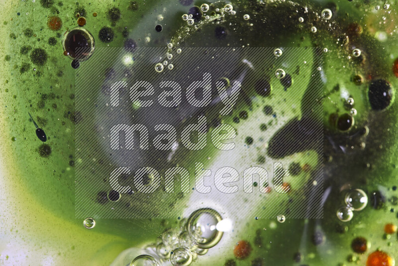 Close-ups of abstract red, green and blue watercolor drops on oil Surface on green background
