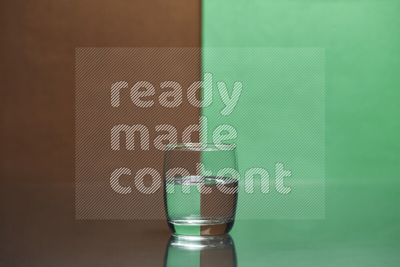 The image features a clear glassware filled with water, set against brown and green background