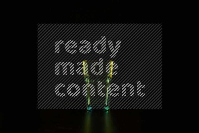 Glassware with rim light in yellow against black background