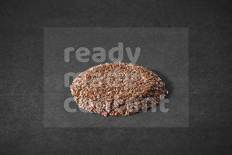 Flax Seeds in a circle shape on a black Flooring