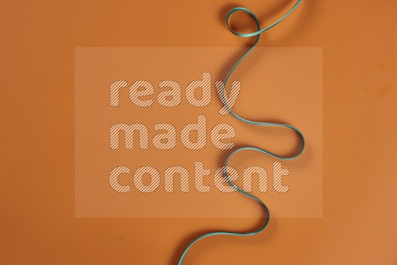 مجموعة من أدوات الخياطة والتفصيل خضراء وبرتقالية اللون على خلفية برتقالية