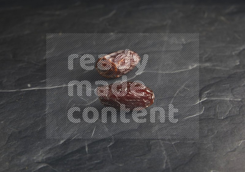 two madjoul dates on a black textured background