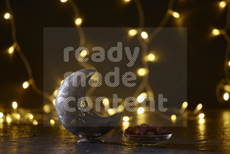 A traditional ramadan lantern surrounded by glowing fairy lights in a dark setup