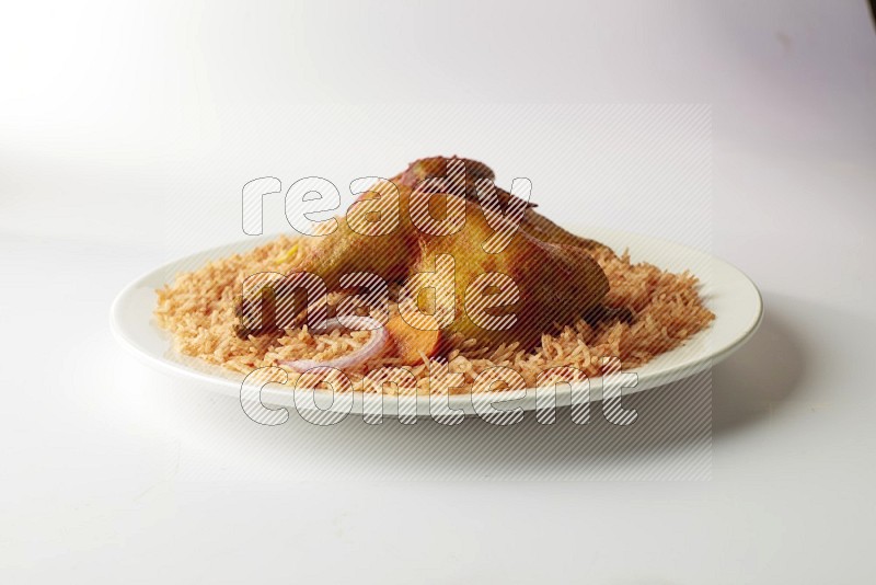 red basmati Rice with kabsa chicken pieces on a white rounded plate direct on white background
