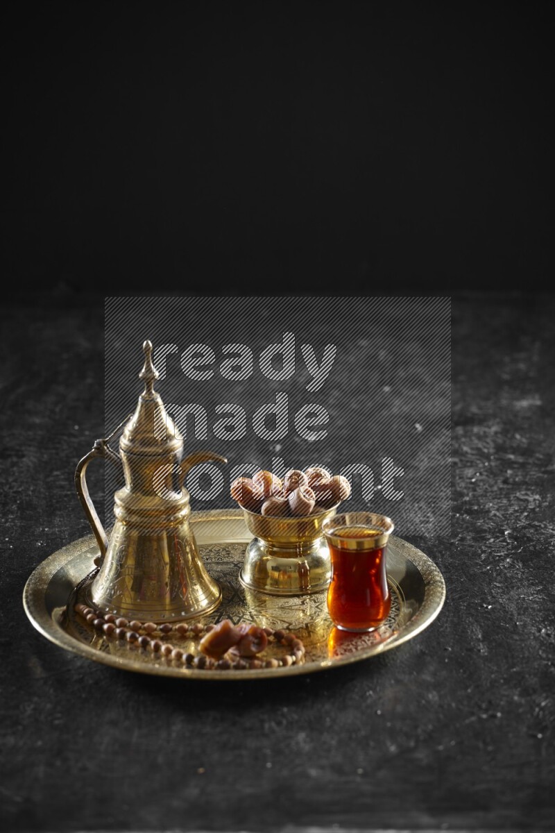 Dates with a drink on a metal tray in a dark setup