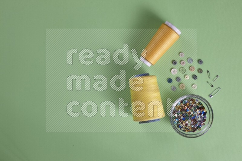 A collection of sewing and tailoring tools arranged on a green background