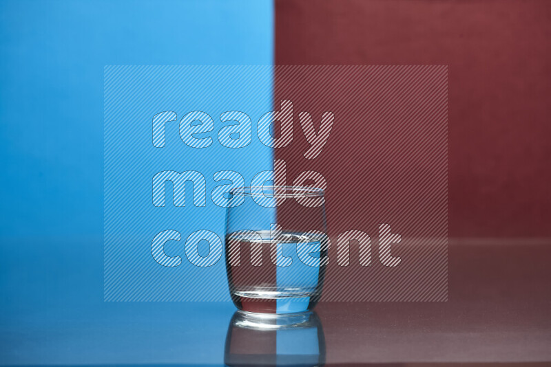 The image features a clear glassware filled with water, set against blue and dark red background