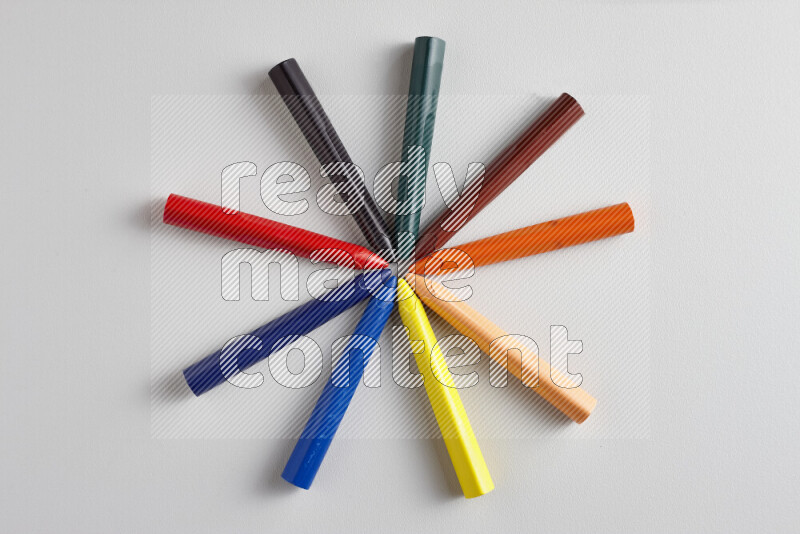 An arrangement of wax crayons in different colors on grey background