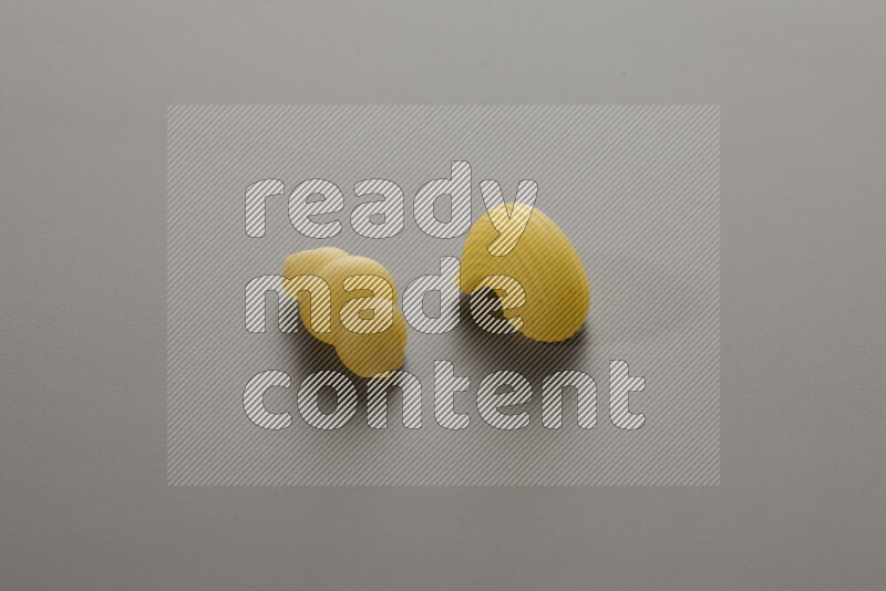 Snails pasta with other types of pasta on grey background