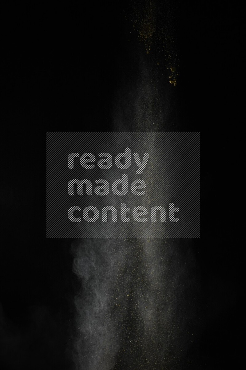 A side view of yellow powder explosion on black background