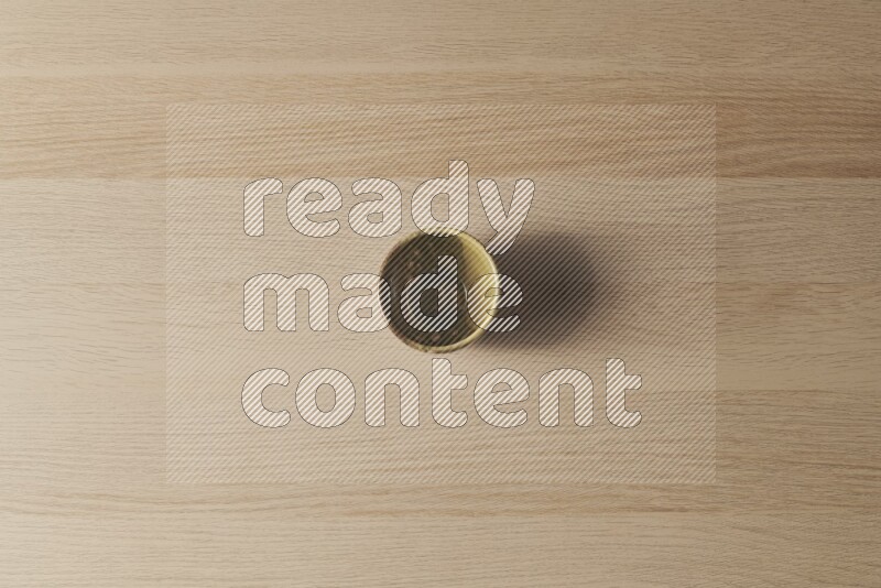A multicolored pottery cup on light wooden background