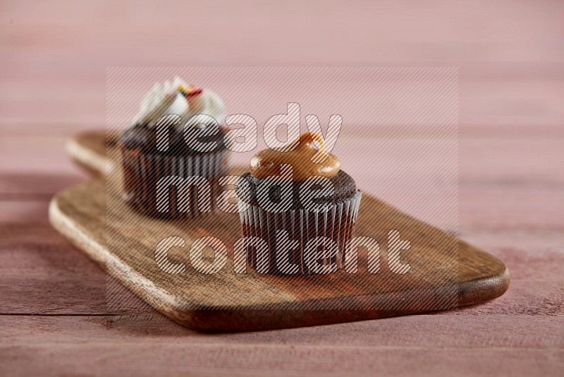 Chocolate mini cupcake topped with peanut butter on a wooden board