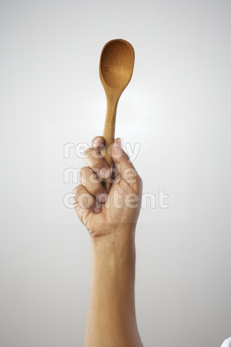 Male Hand Holding Wooden spoon on white background
