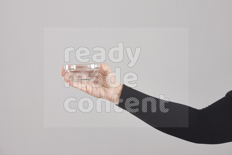 امرأة ترتدي عباءة سوداء تحمل أدوات زجاجية مختلفة في أوضاع متعددة